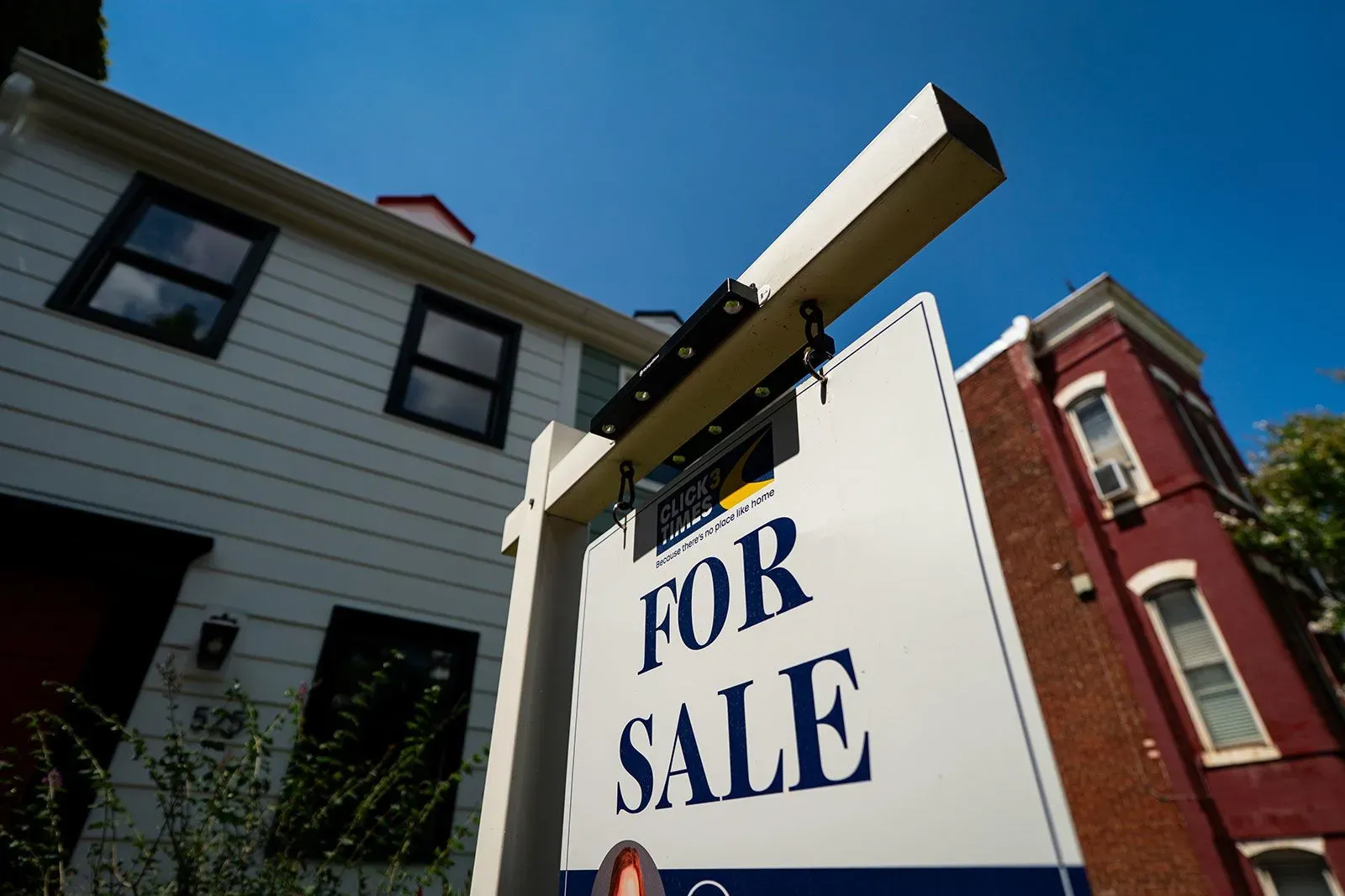 لافتة "للبيع" أمام منزل، تعكس حالة سوق الإسكان الحالية وسط تغيرات أسعار الفائدة والقلق الاقتصادي.