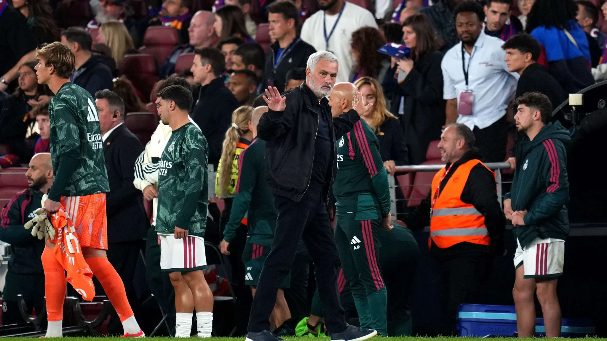 جوزيه مورينيو مدرب ريال مدريد يلوح بيده على خط الملعب خلال مباراة ضد برشلونة في الدوري الإسباني، مع لاعبي الفريق في الخلفية.