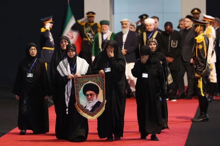 نساء يرتدين العباءات السوداء يحملن صورة آية الله علي خامنئي خلال مراسم العزاء الرسمية في طهران بحضور مسؤولين ودبلوماسيين.