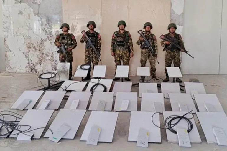 أفراد من جيش ميانمار يقفون أمام 30 قمرًا صناعيًا من ستارلينك تم الاستيلاء عليها خلال مداهمة لمركز احتيال في كي كي بارك.