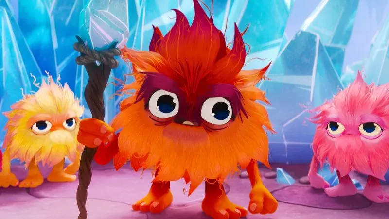 شخصية ماما بوت من فيلم "السنافر"، تظهر مخلوقات ملونة ذات شعر كثيف، في مشهد من مغامراتهم في عالم سحري.