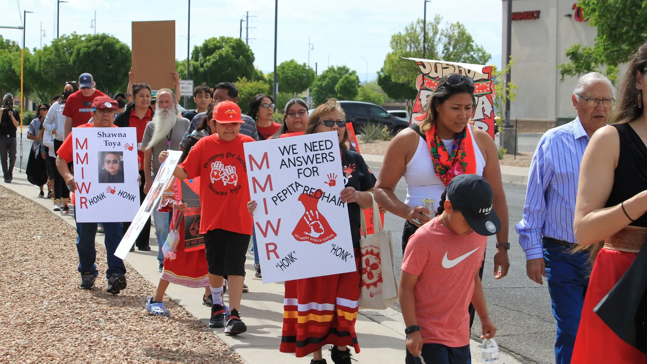 مجموعة من الأشخاص يسيرون في مسيرة، يحملون لافتات تطالب بالعدالة للسكان الأصليين المفقودين والمقتولين، في ولاية نيو مكسيكو.