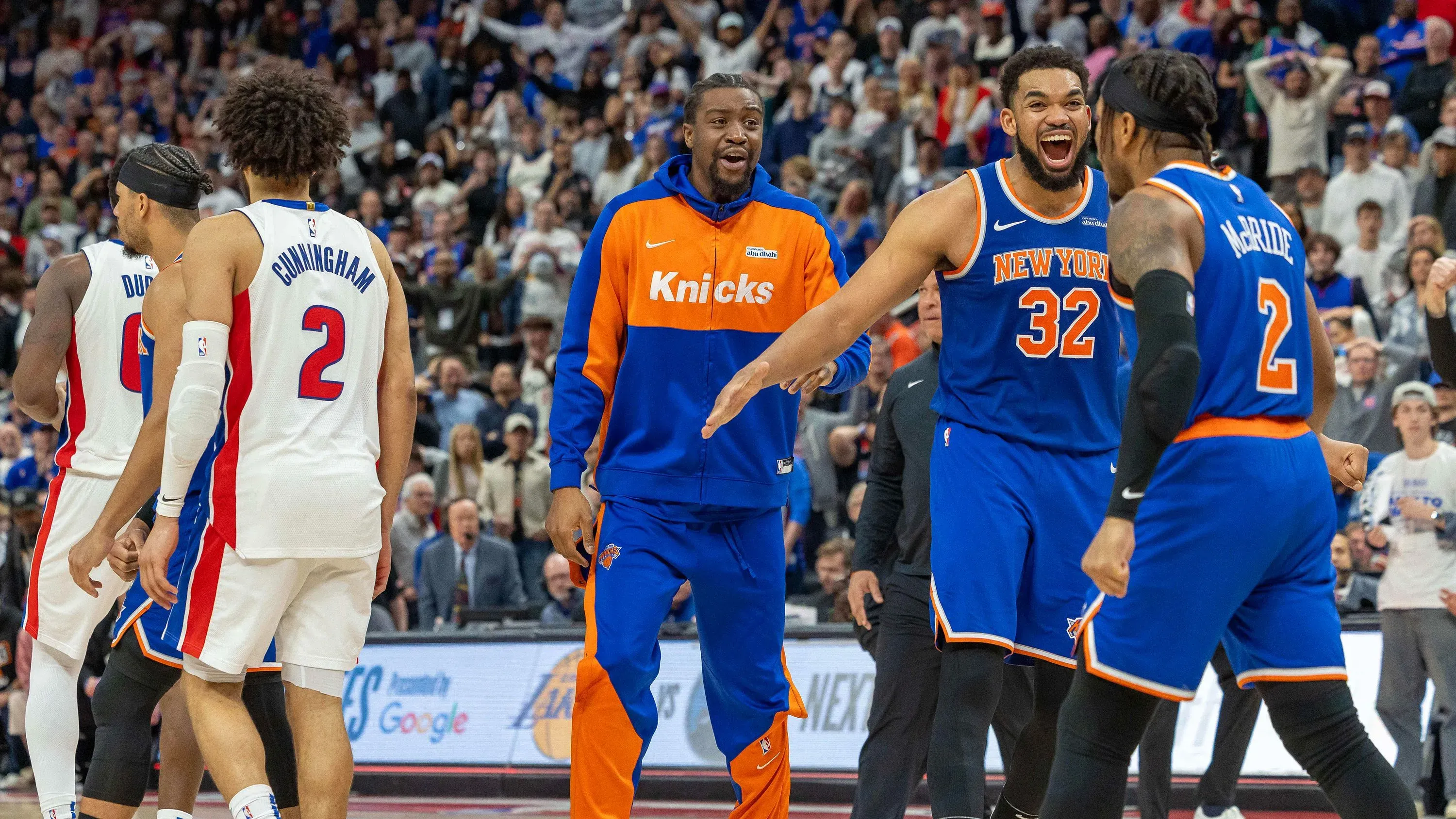 احتفال لاعبي نيويورك نيكس بعد الفوز على ديترويت بيستونز في مباراة حاسمة، مع تفاعل الجماهير في الخلفية.