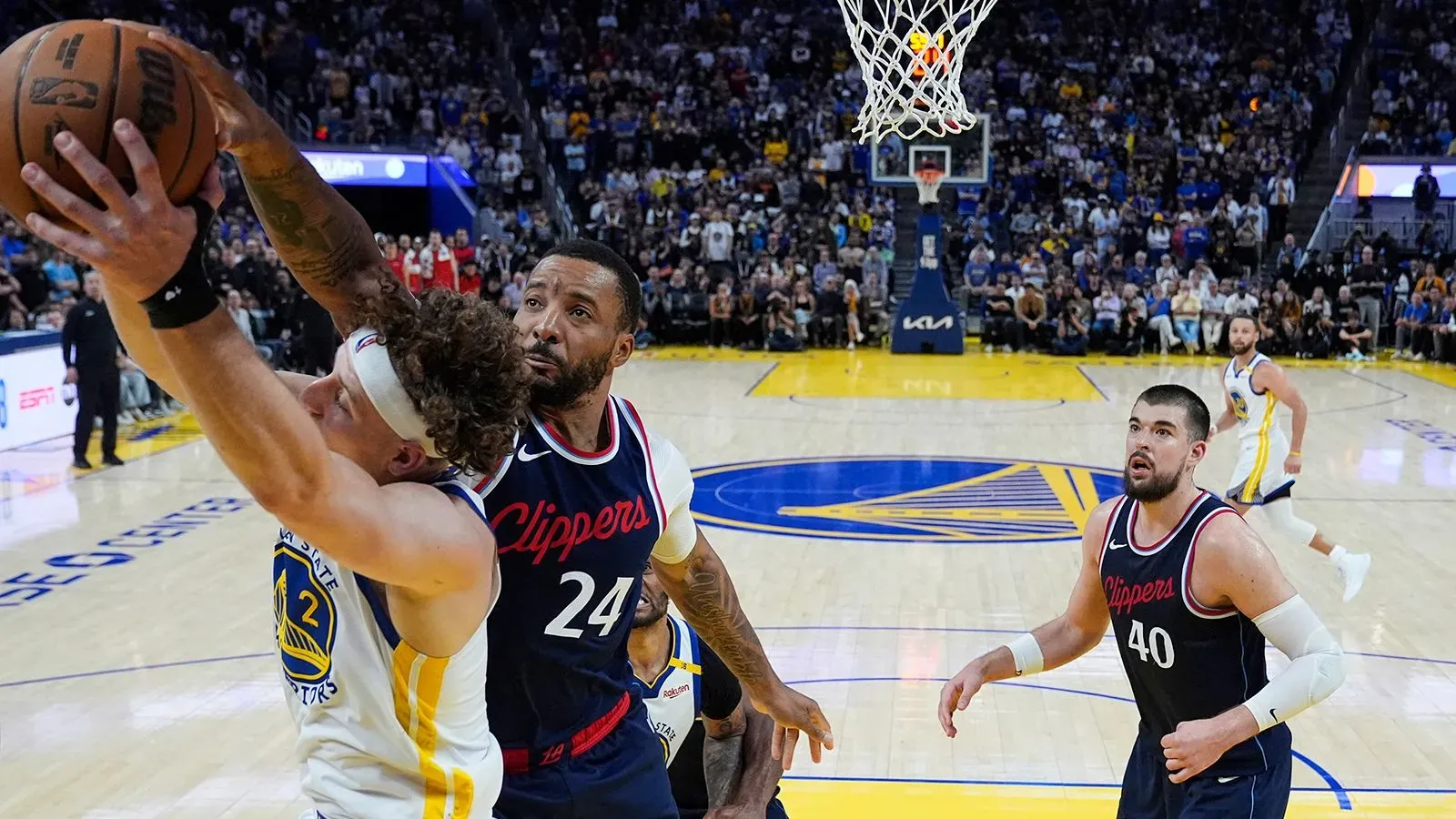 لاعب من فريق لوس أنجلوس كليبرز يتصدى للاعب من فريق جولدن ستيت ووريورز أثناء مباراة حاسمة في دوري كرة السلة الأمريكي للمحترفين.