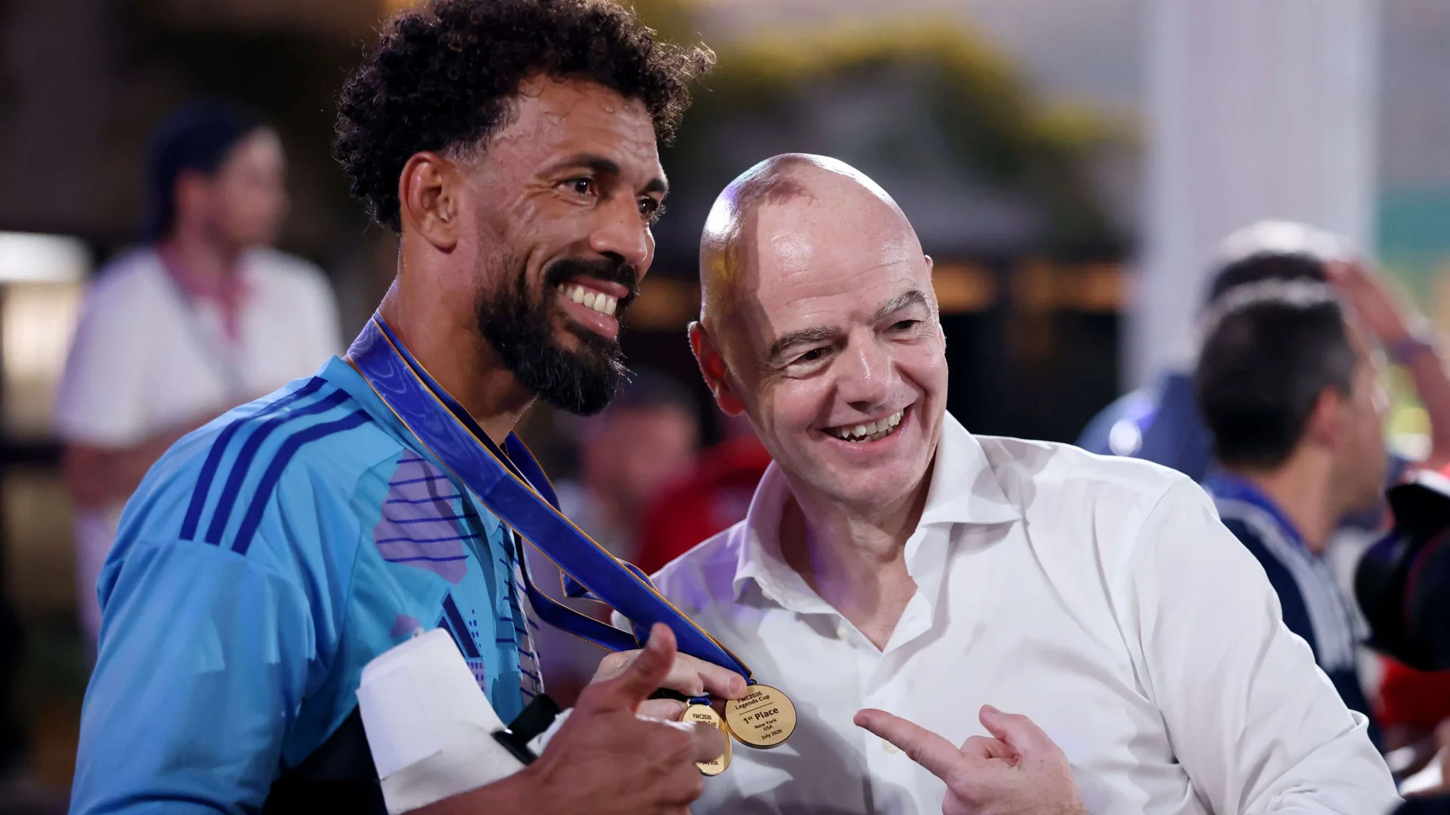رئيس FIFA جياني إنفانتينو يبتسم مع لاعب يحمل ميداليات كأس العالم 2026 في أجواء احتفالية بعد انتهاء البطولة.