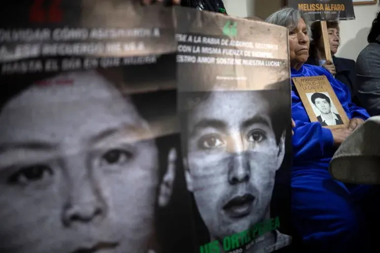 نساء يحملن لافتات تحمل صور ضحايا انتهاكات حقوق الإنسان في بيرو خلال مؤتمر صحفي لمعارضة قانون العفو عن أفراد الجيش والشرطة.