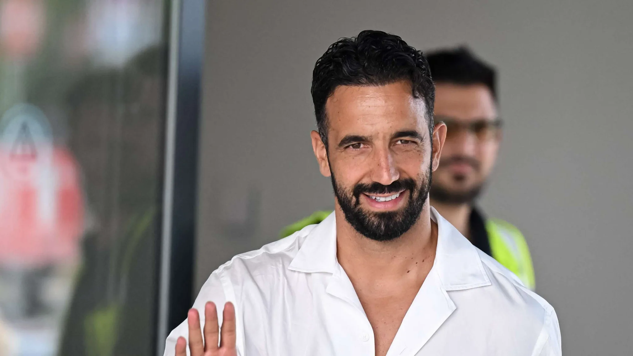 لاعب كرة القدم لوكا مودريتش يلوّح بيده مبتسماً، مع خلفية ضبابية لشخص آخر، في سياق الحديث عن مستقبله مع المنتخب الكرواتي وميلان.