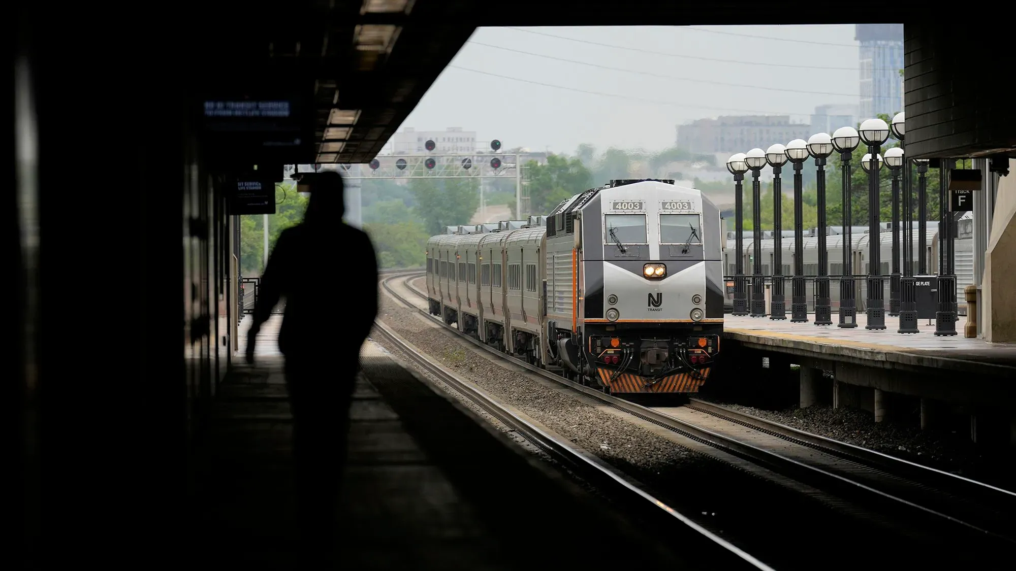 قطار نيوجيرسي ترانزيت يصل إلى المحطة، مع وجود شخص واقف في الظل، في ظل تصاعد القلق حول الإضراب وتأثيره على الركاب والحفلات الموسيقية.
