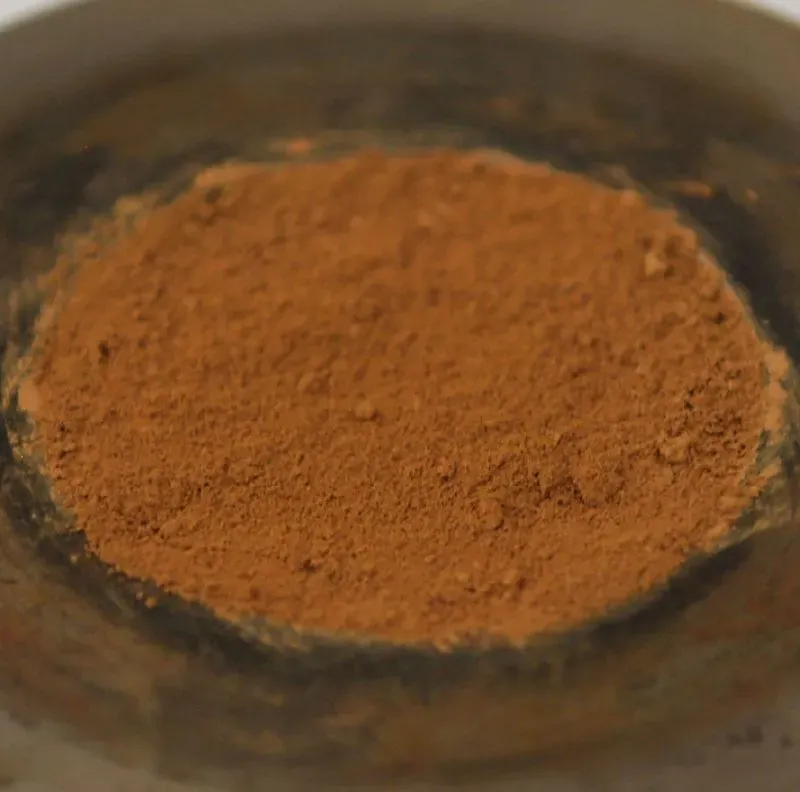 غبار بني محمر يظهر في وعاء، يعكس التركيب المعدني للمريخ ويشير إلى وجود أكسيد الحديد، مما يساعد في فهم تاريخ الكوكب.