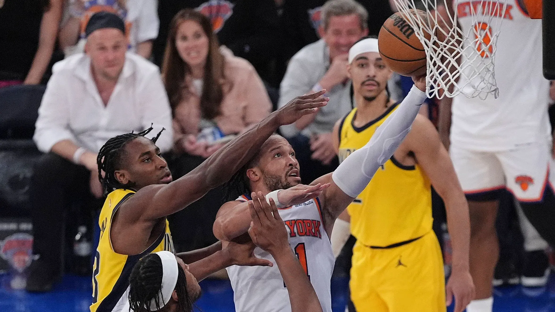 لاعب نيويورك نيكس يحاول تسجيل نقطة بينما يتصدى له لاعب إنديانا بيسرز في مباراة حماسية ضمن نهائيات البطولة الشرقية.