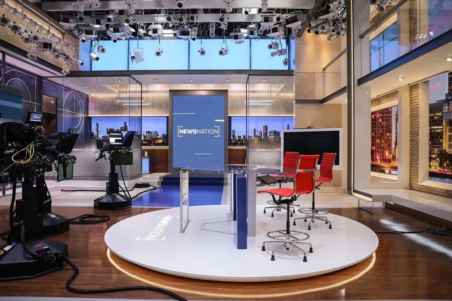 استوديو أخبار حديث مع كاميرات ومعدات بث، يظهر شعار "NEWSNATION" على الشاشة الخلفية، يعكس التوجه نحو التغطية الإخبارية المحلية.