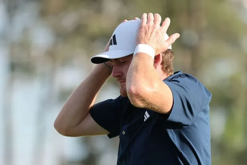 لاعب غولف يبدو عليه الإحباط بعد جولة سيئة في بطولة الماسترز، حيث يضع يديه على رأسه تعبيرًا عن خيبة الأمل.