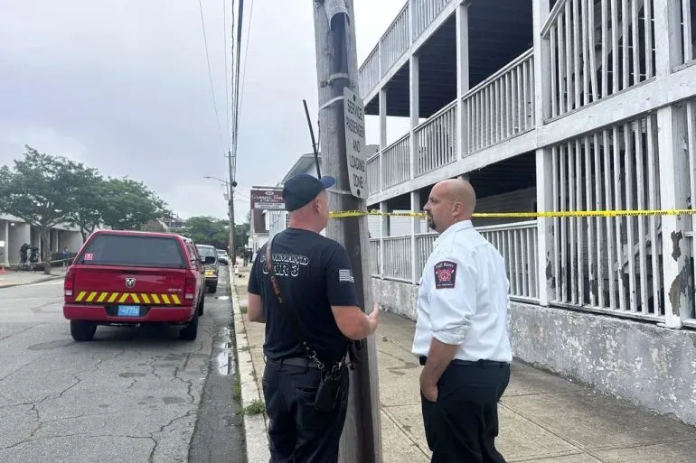 رجلا إطفاء يتحدثان بالقرب من موقع حريق في منشأة للمساعدة على المعيشة في فال ريفر، ماساتشوستس، بعد الحادث المأساوي الذي أسفر عن وفيات وإصابات.