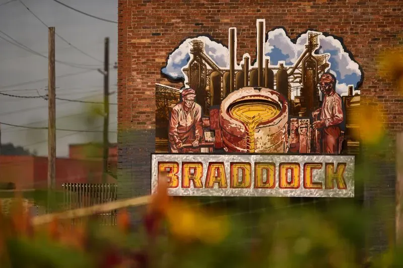 جدارية ملونة في مدينة برادوك تُظهر عمال الصلب مع أفران الصهر، تعكس تاريخ صناعة الصلب في أمريكا.