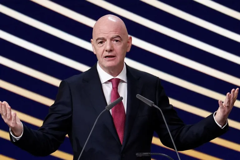 جياني إنفانتينو رئيس FIFA يتحدث أمام ميكروفونات مع خلفية خطوط مائلة، وسط ضغوط من اتحادات شمال أوروبا لمطالبته بالإصلاحات.