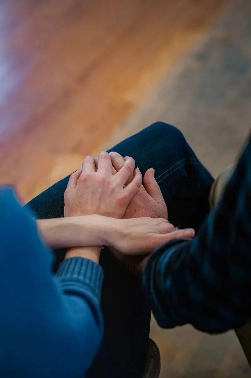 أيدٍ متشابكة تعكس الدعم والتعاطف بين الأفراد، في سياق جهود التعافي بعد إعصار هيلين في كارولينا الشمالية.