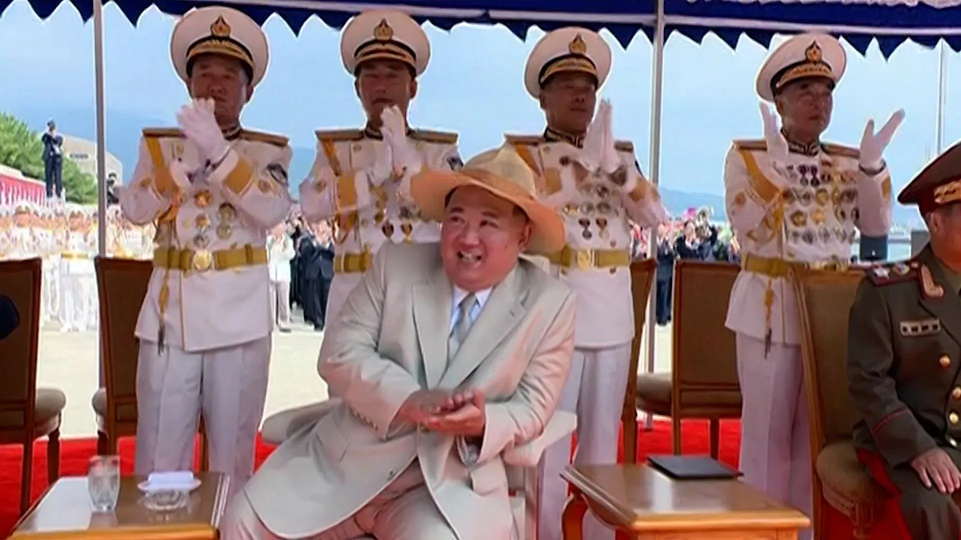 صورة تظهر كيم جونغ أون محاطًا بالجنرالات خلال احتفال، حيث يعبر عن الفخر بعد إطلاق فاشل لسفينة حربية في كوريا الشمالية.