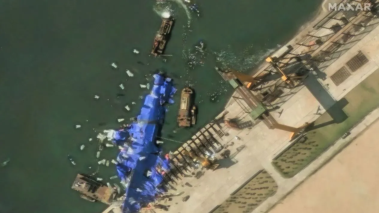 بالونات بيضاء تُستخدم حول مدمرة كورية شمالية متضررة، مع وجود سفن وأدوات إصلاح في الموقع، في محاولة لإعادتها إلى وضعها المستقر.