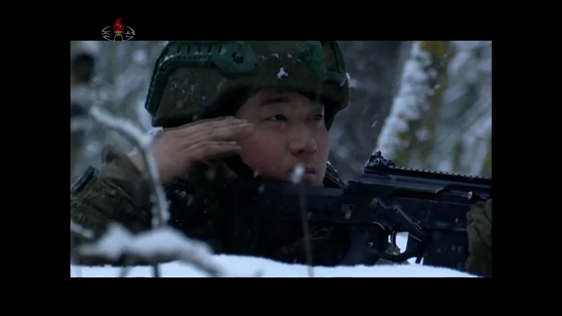 جندي كوري شمالي في ساحة المعركة المغطاة بالثلوج، يؤدي التحية العسكرية ويحمل سلاحه، في سياق الدعاية العسكرية لدعم روسيا.