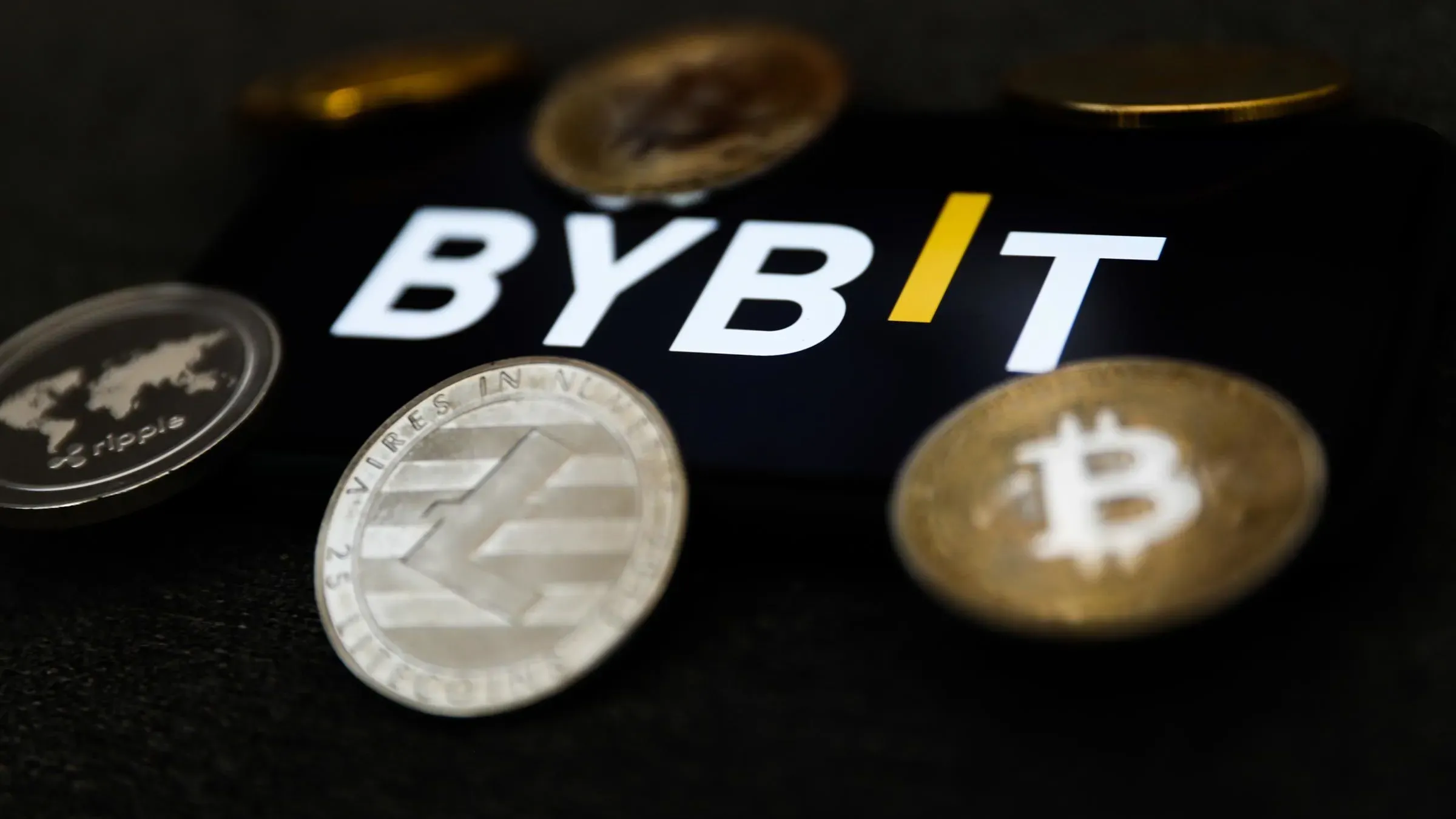شعار شركة Bybit مع عملات رقمية متنوعة حوله، في سياق أكبر عملية اختراق للعملات الرقمية بقيمة 1.5 مليار دولار.