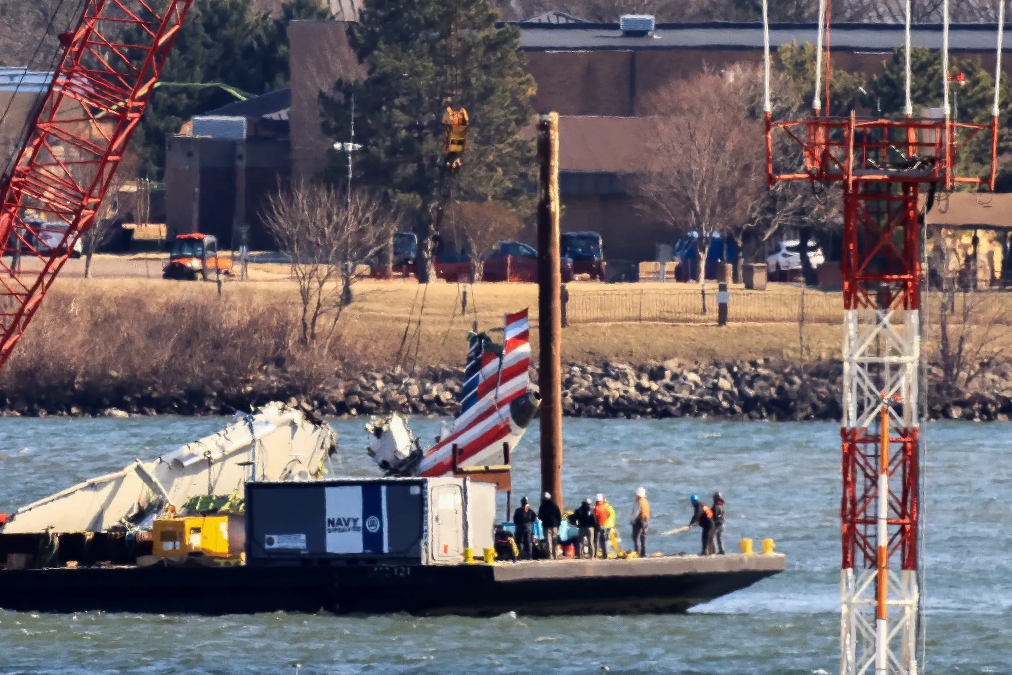 عملية رفع حطام مروحية بلاك هوك في نهر بوتوماك، مع وجود عمال ومعدات على متن بارجة، قرب مطار رونالد ريجان.