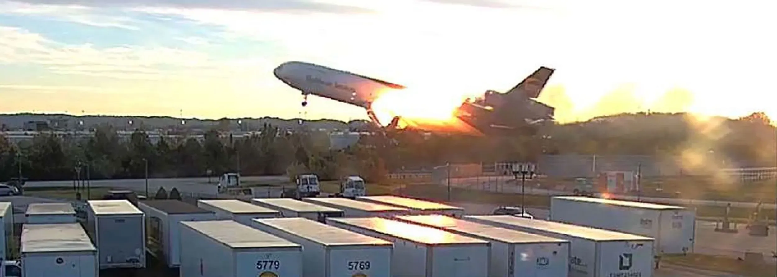 طائرة UPS MD-11F تحلق بشكل غير مستقر بعد انفصال المحرك الأيسر، مع تصاعد النيران والدخان خلفها، في حادث مأساوي بلويزفيل.