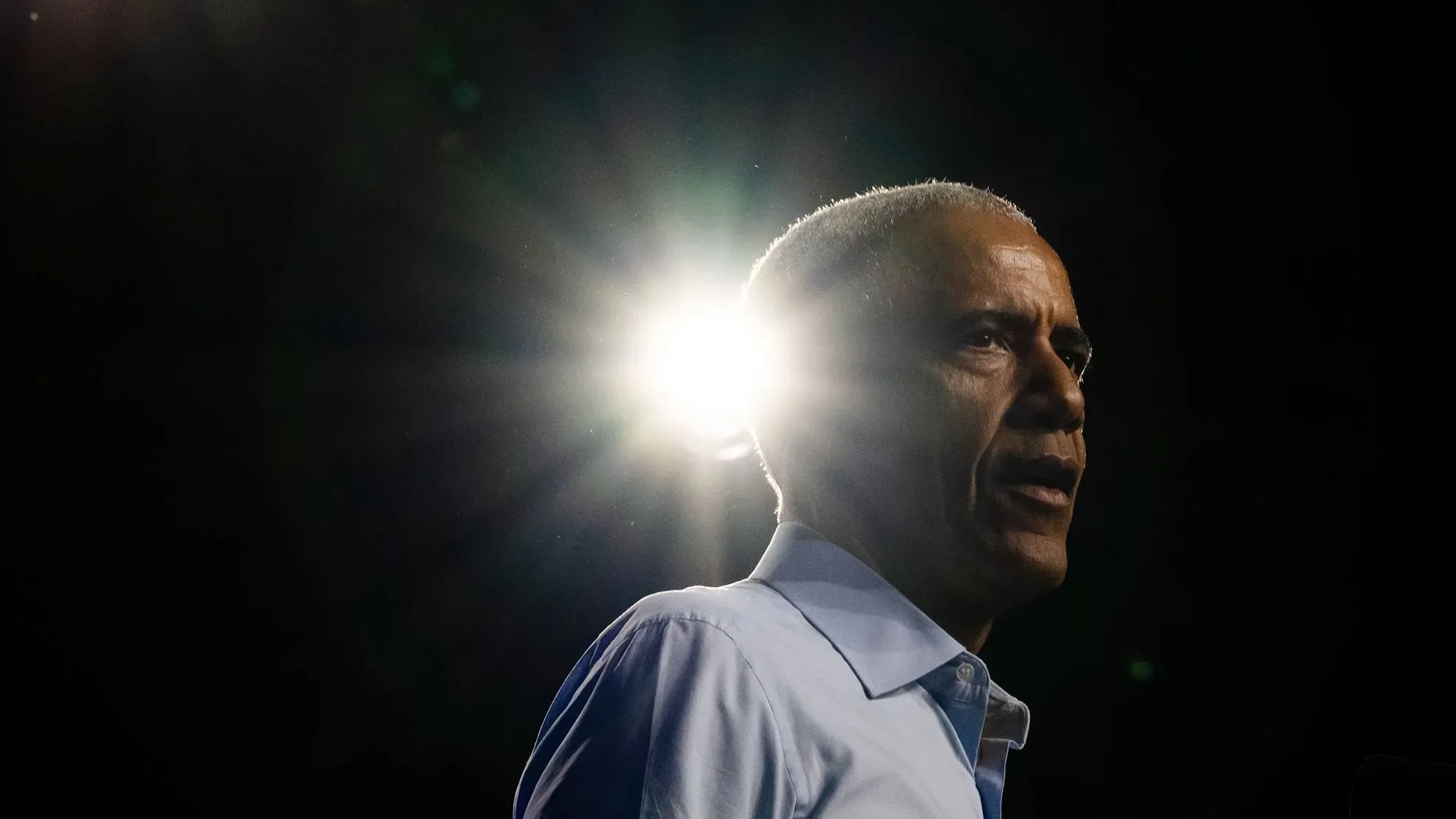 باراك أوباما يتحدث في منتدى كونيتيكت، مع إضاءة خلفية، مشدداً على أهمية الدفاع عن الديمقراطية في ظل التحديات الحالية.