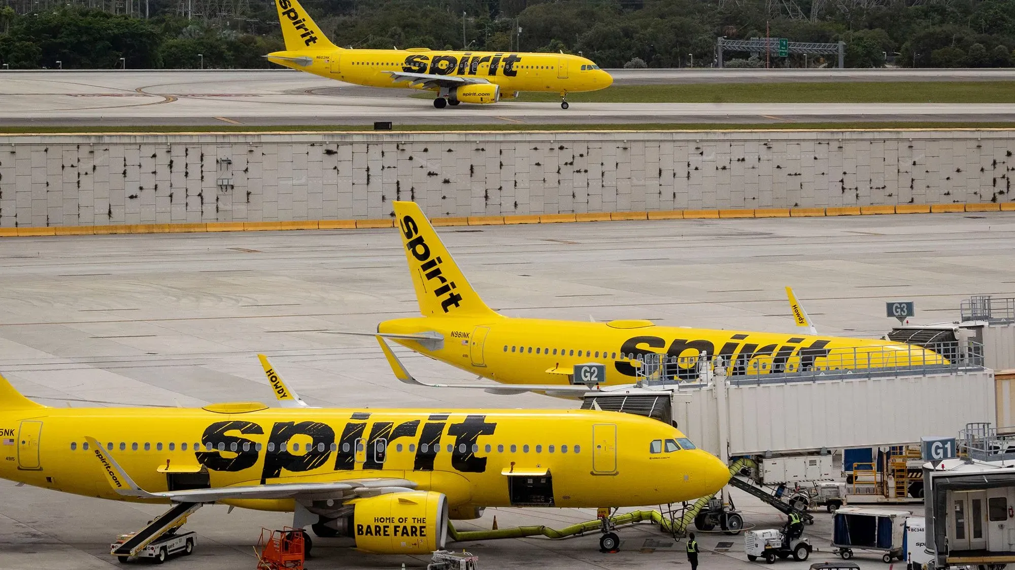 طائرات خطوط سبيريت الجوية بلونها الأصفر المميز في مطار، تعكس التحديثات الجديدة لسياسات الملابس للمسافرين.
