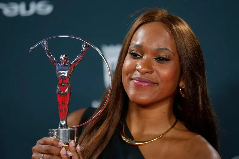 أندرادي تحمل جائزة لوريوس العالمية للرياضة، مبتسمة بفخر، تعكس إنجازاتها التاريخية في الجمباز الأولمبي.