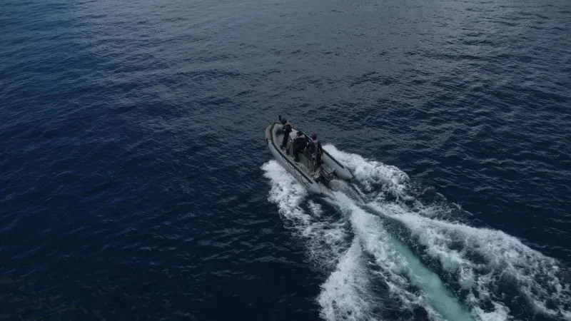 قارب سريع يحمل عدة أشخاص يبحر في مياه المحيط الهادئ، مستخدمًا كغطاء لتهريب المخدرات في منطقة جزر غالاباغوس.