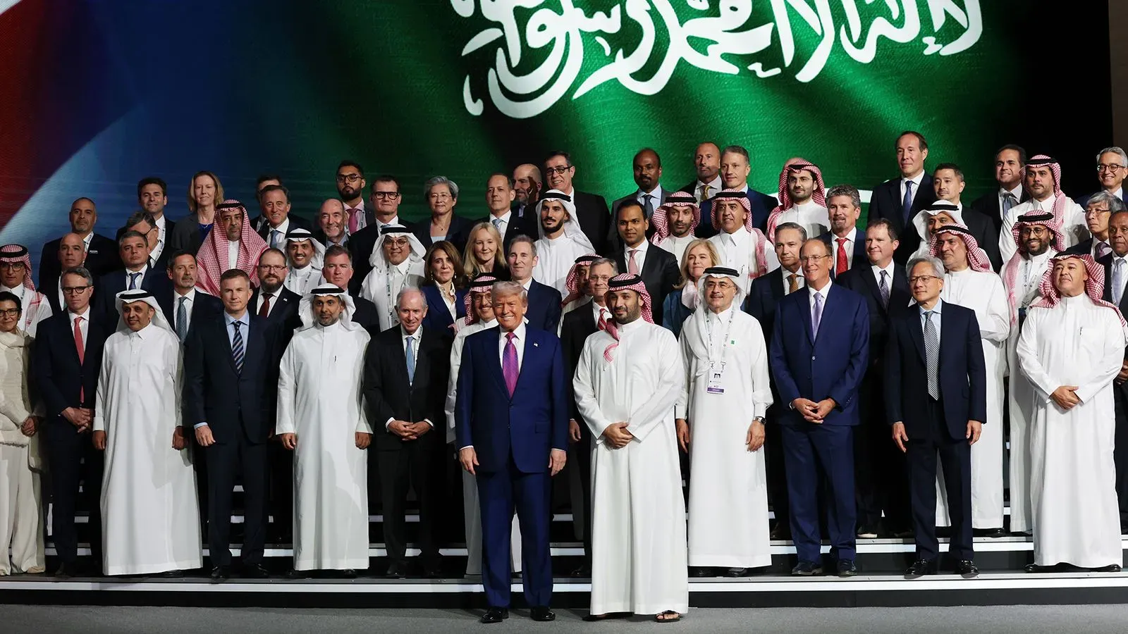 اجتماع لعدد من الرؤساء التنفيذيين الأمريكيين مع الرئيس ترامب في السعودية، مع خلفية تحمل شعار المملكة، خلال زيارة تاريخية لتعزيز شراكات الذكاء الاصطناعي.