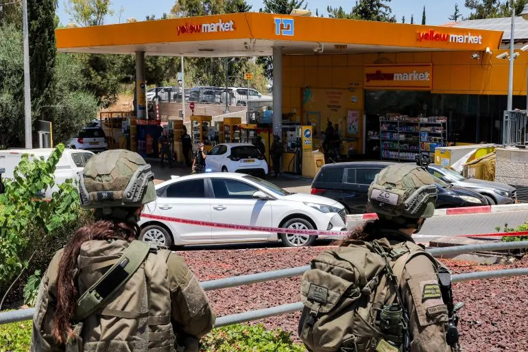 موقع الحادثة في محطة وقود، حيث يتواجد جنود إسرائيليون يتابعون الوضع بعد هجوم مسلح أسفر عن مقتل شخص وإصابة آخرين.