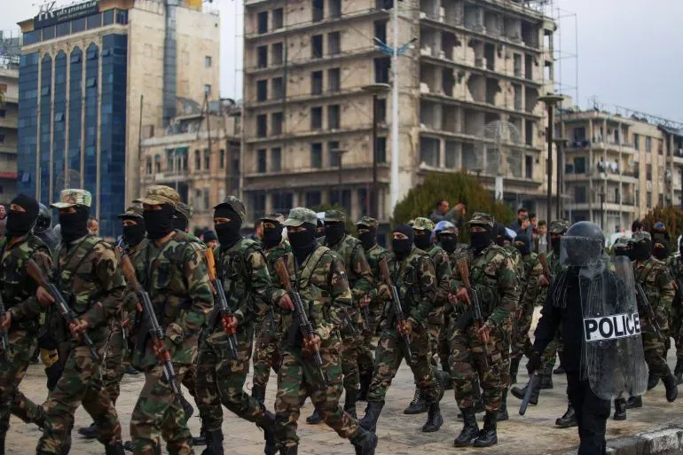 عناصر من قوات الأمن السورية يرتدون زياً عسكرياً ويستعرضون في شوارع حلب، وسط أجواء توتر بعد اشتباكات مع قوات سوريا الديمقراطية.