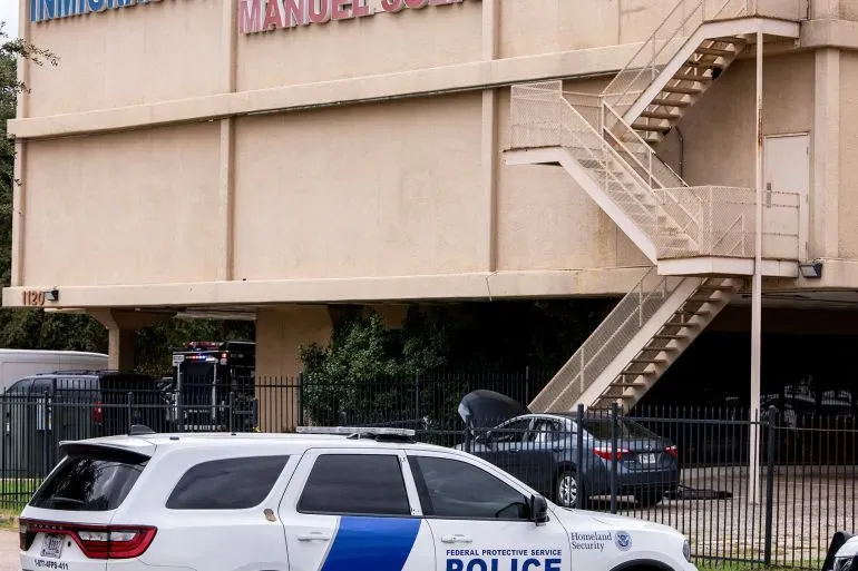 مكتب إنفاذ قوانين الهجرة والجمارك في دالاس، مع وجود سيارة شرطة تابعة للخدمة الفيدرالية أمام المبنى، بعد حادث إطلاق نار.