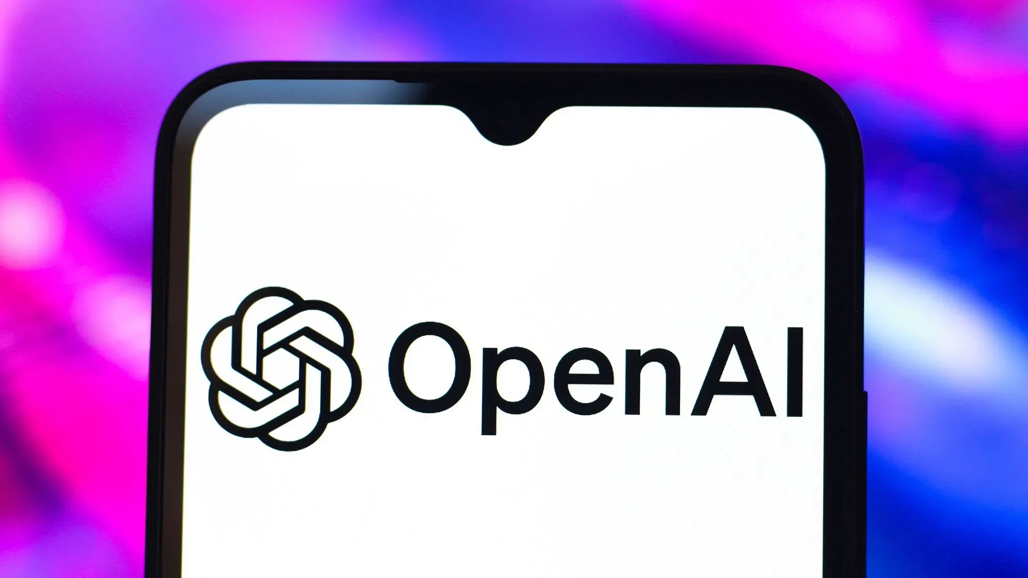 شعار OpenAI يظهر على شاشة هاتف ذكي، مع خلفية ملونة تعكس الابتكار في مجال الذكاء الاصطناعي.