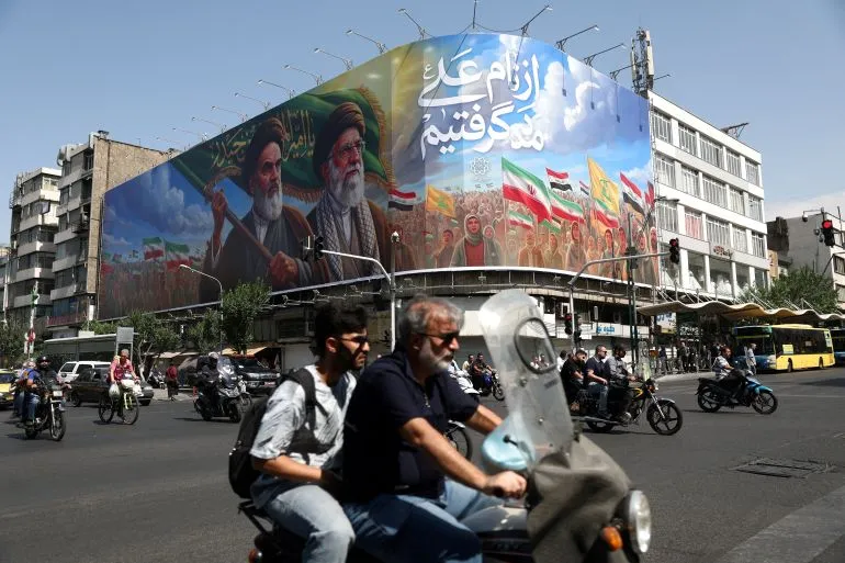 جدارية كبيرة في طهران تظهر شخصيات سياسية إيرانية مع أعلام، تعكس التوترات الإقليمية وتطلعات إيران في ظل المفاوضات النووية.