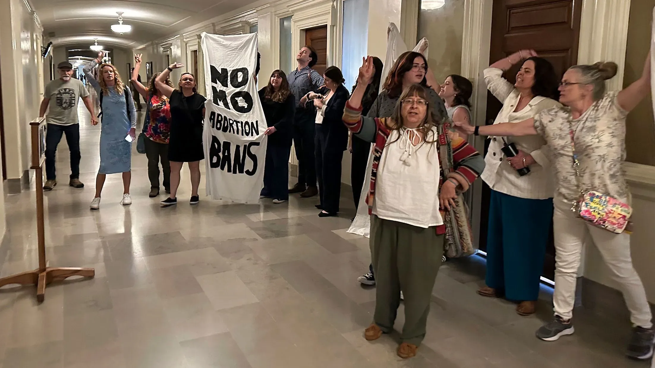 مجموعة من النشطاء يحتجون في ممر حكومي، يحملون لافتة كتب عليها "لا لحظر الإجهاض"، تعبيراً عن دعمهم لحقوق الإجهاض في ميسوري.
