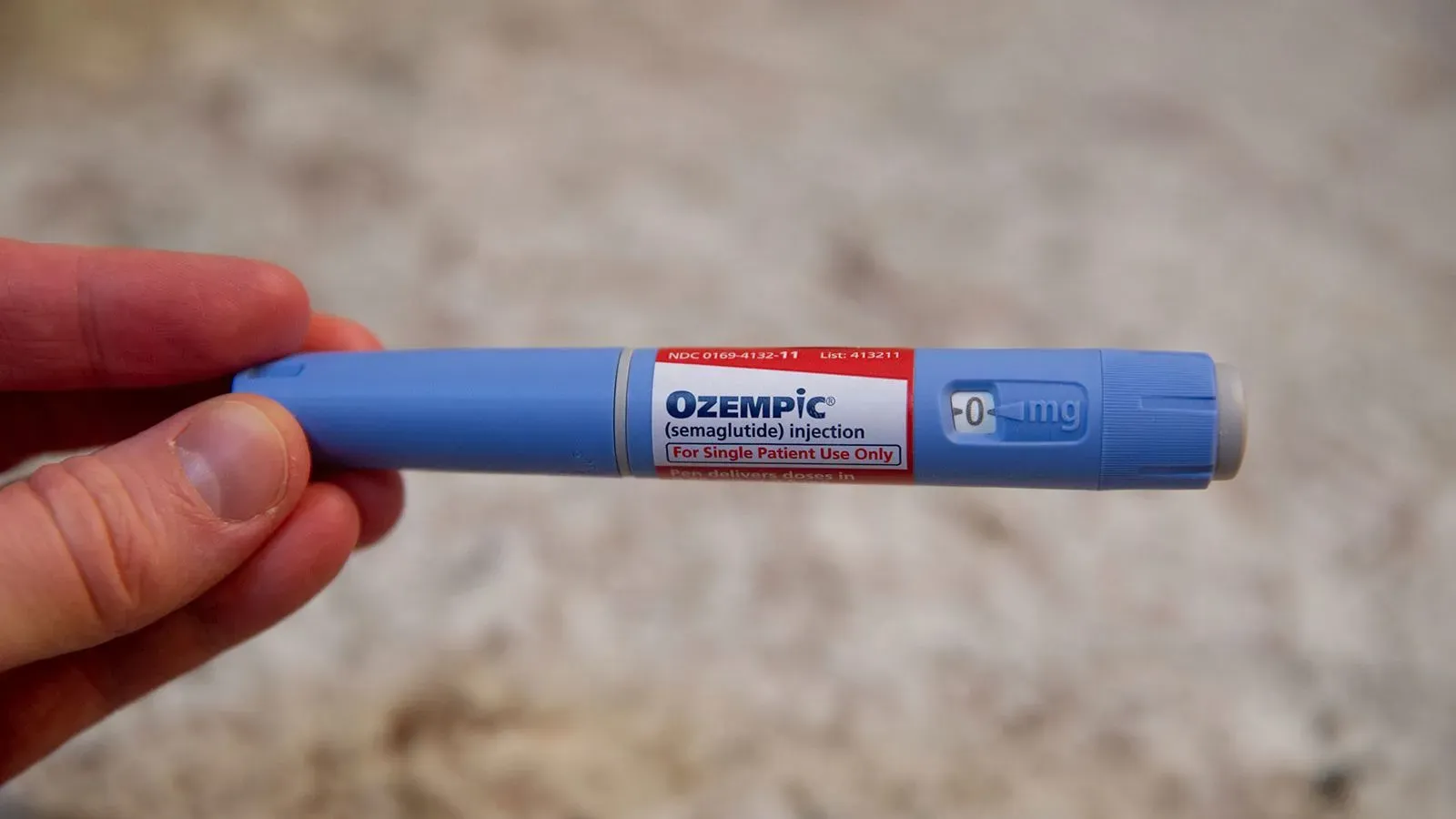 قلم حقن دواء أوزيمبيك (سيماجلوتايد)، المستخدم لعلاج السكري وفقدان الوزن، يظهر في يد شخص.