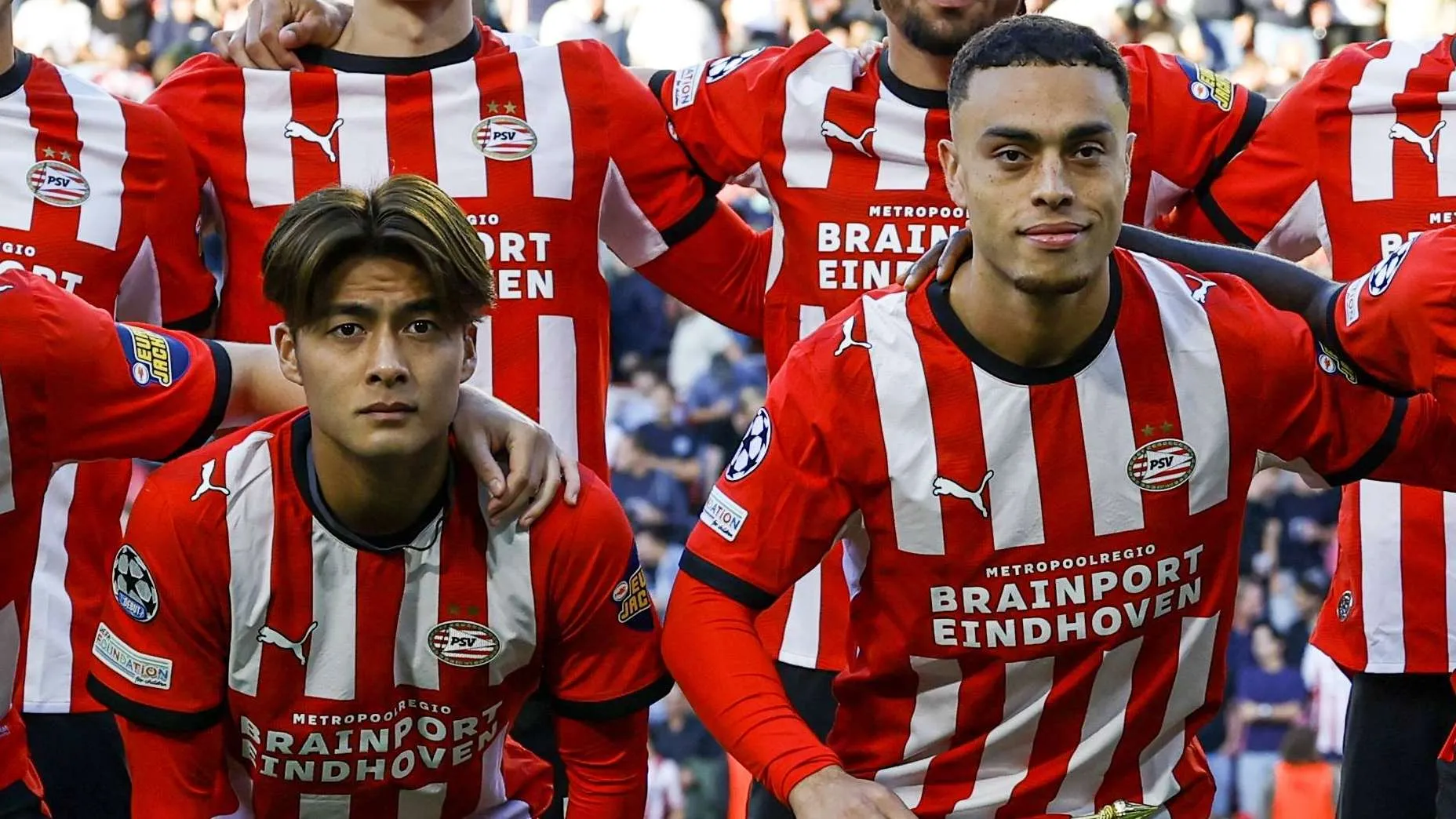 لاعبو فريق PSV Eindhoven يرتدون الزي الأحمر والأبيض قبل مباراة دوري أبطال أوروبا، مع التركيز على لاعب وسط كوداي سانو في أول ظهور له.