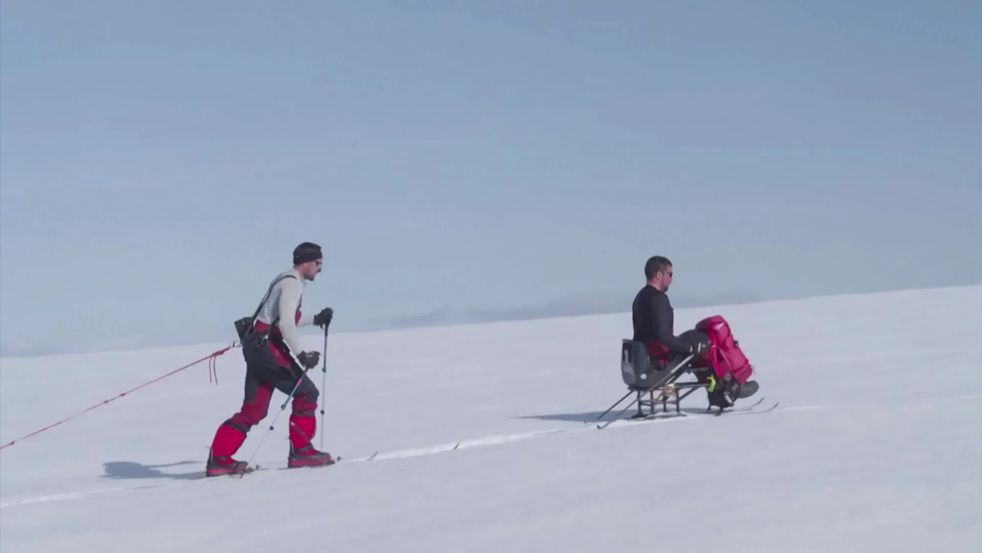 دارين إدواردز يتزلج باستخدام زلاجة جلوس بينما يسحبه صديقه عبر الثلوج في القارة القطبية الجنوبية، مظهرًا تحدياته كأحد المغامرين المعاقين.