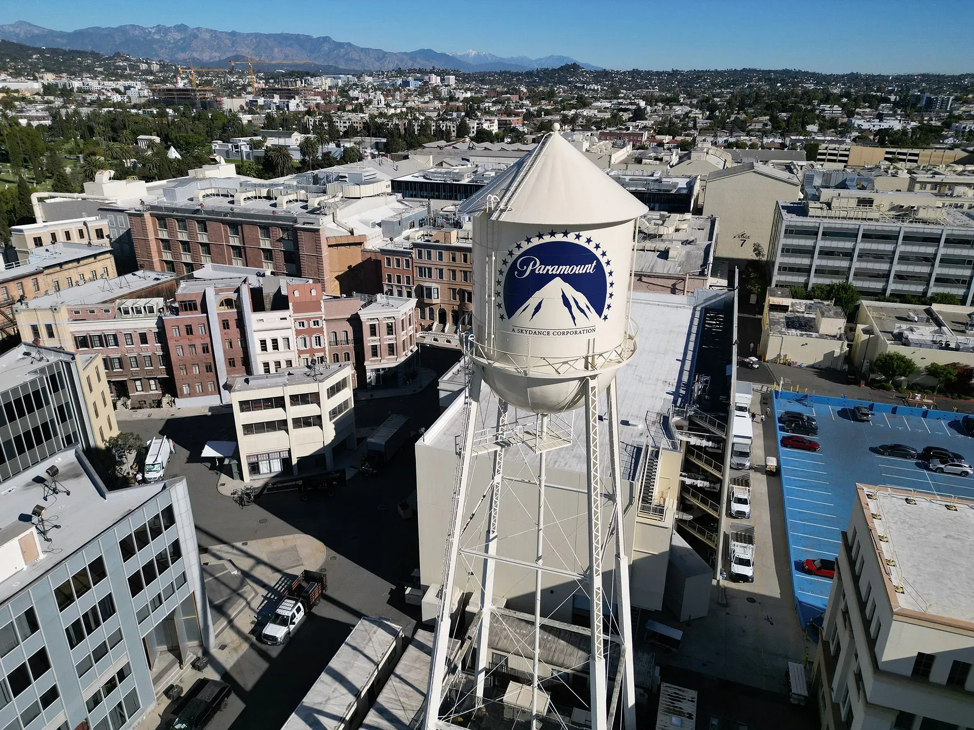 صورة جوية لمجمع باراماونت السينمائي، تظهر خزان المياه المميز بشعار باراماونت، مع خلفية للمدينة والجبال.