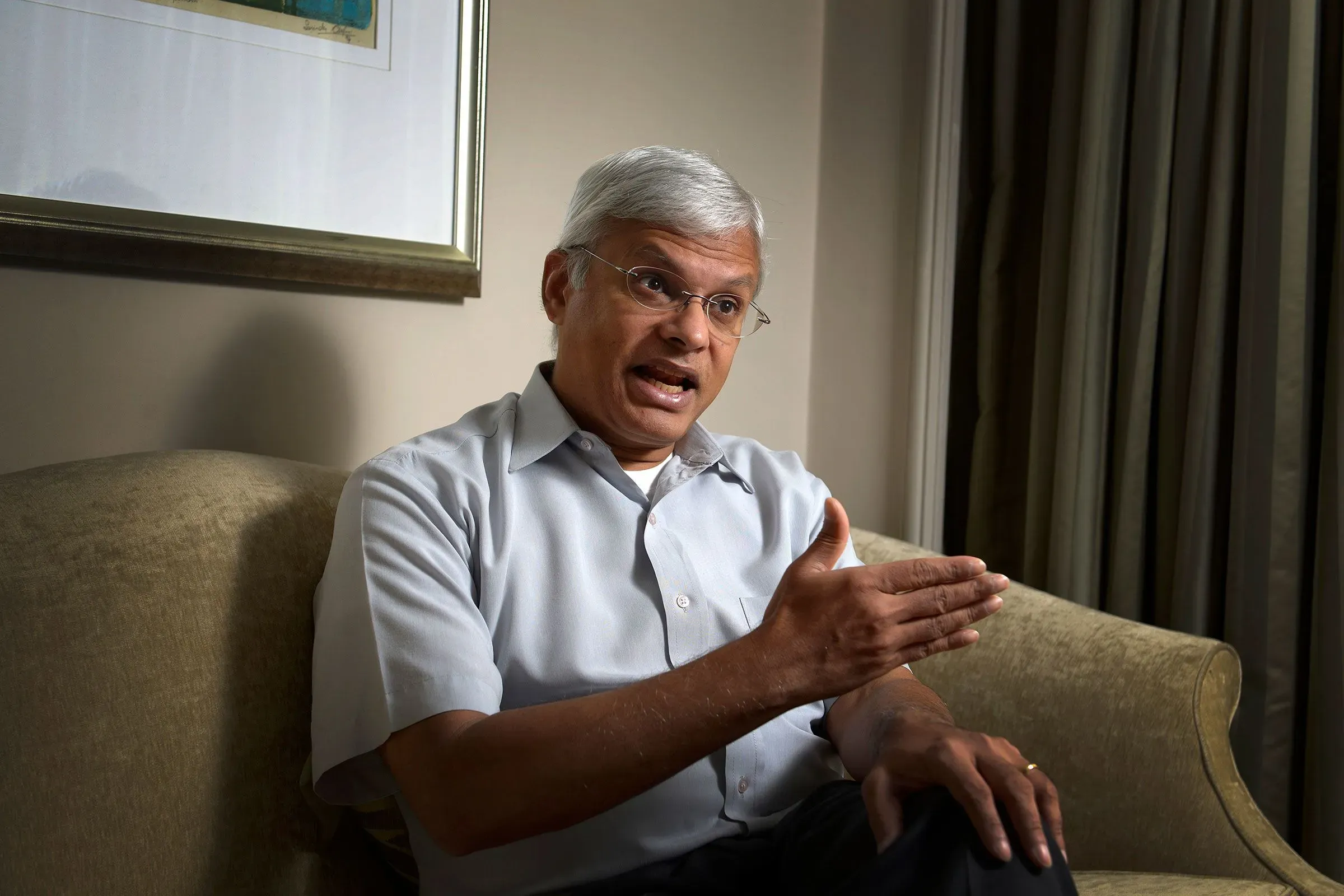 رجل يتحدث بجدية أثناء جلوسه على أريكة، في سياق تحقيقات تتعلق بتسريب معلومات سرية عن الأمن القومي الأمريكي.