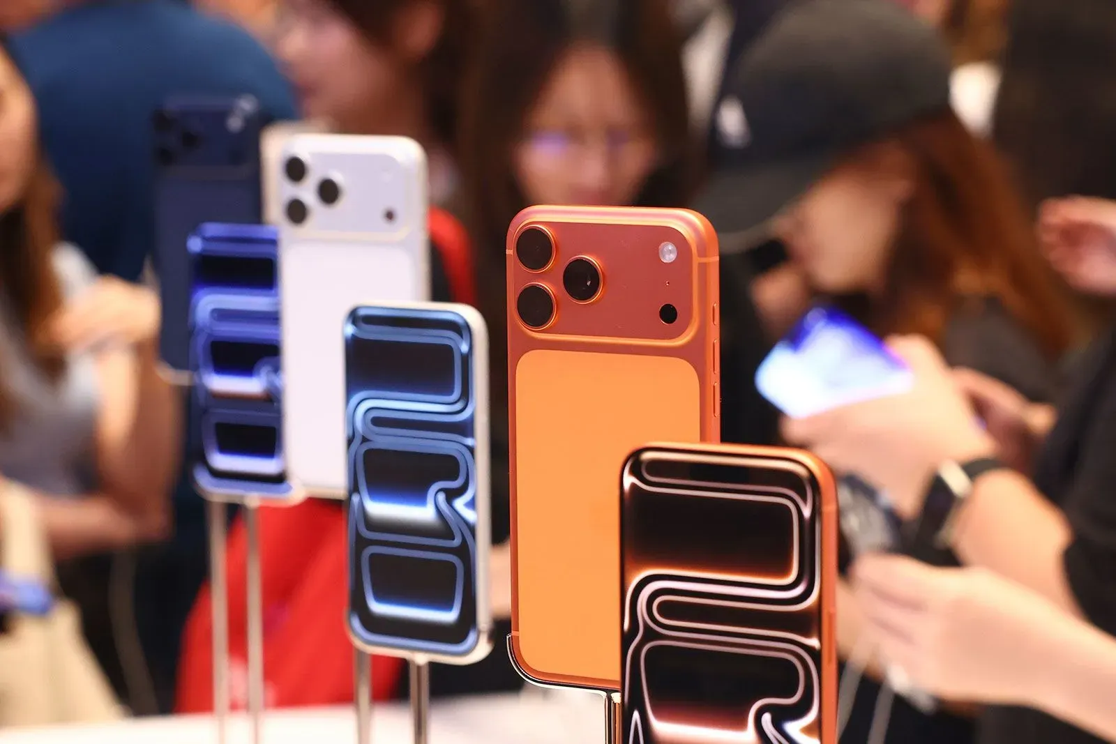 عرض لهواتف iPhone Air بألوان متنوعة، مع التركيز على الطراز البرتقالي. الصورة تظهر اهتمامًا محدودًا من المستهلكين مقارنةً بموديلات iPhone 17.