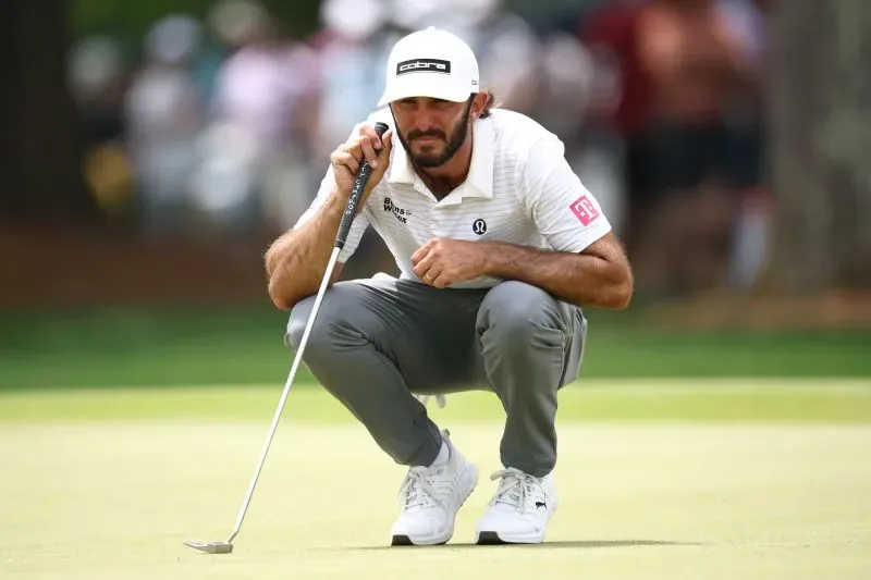 لاعب جولف يركز على تسديدته أثناء بطولة رابطة محترفي الجولف في شارلوت، مع جمهور في الخلفية.