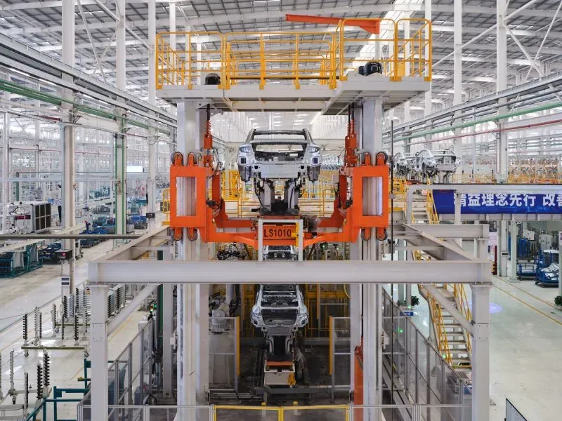 صورة توضح خط إنتاج سيارات كهربائية في مصنع BYD، يظهر فيه هيكل سيارة مع وجود آلات صناعية متطورة، مما يعكس التحول نحو الأتمتة في التصنيع.