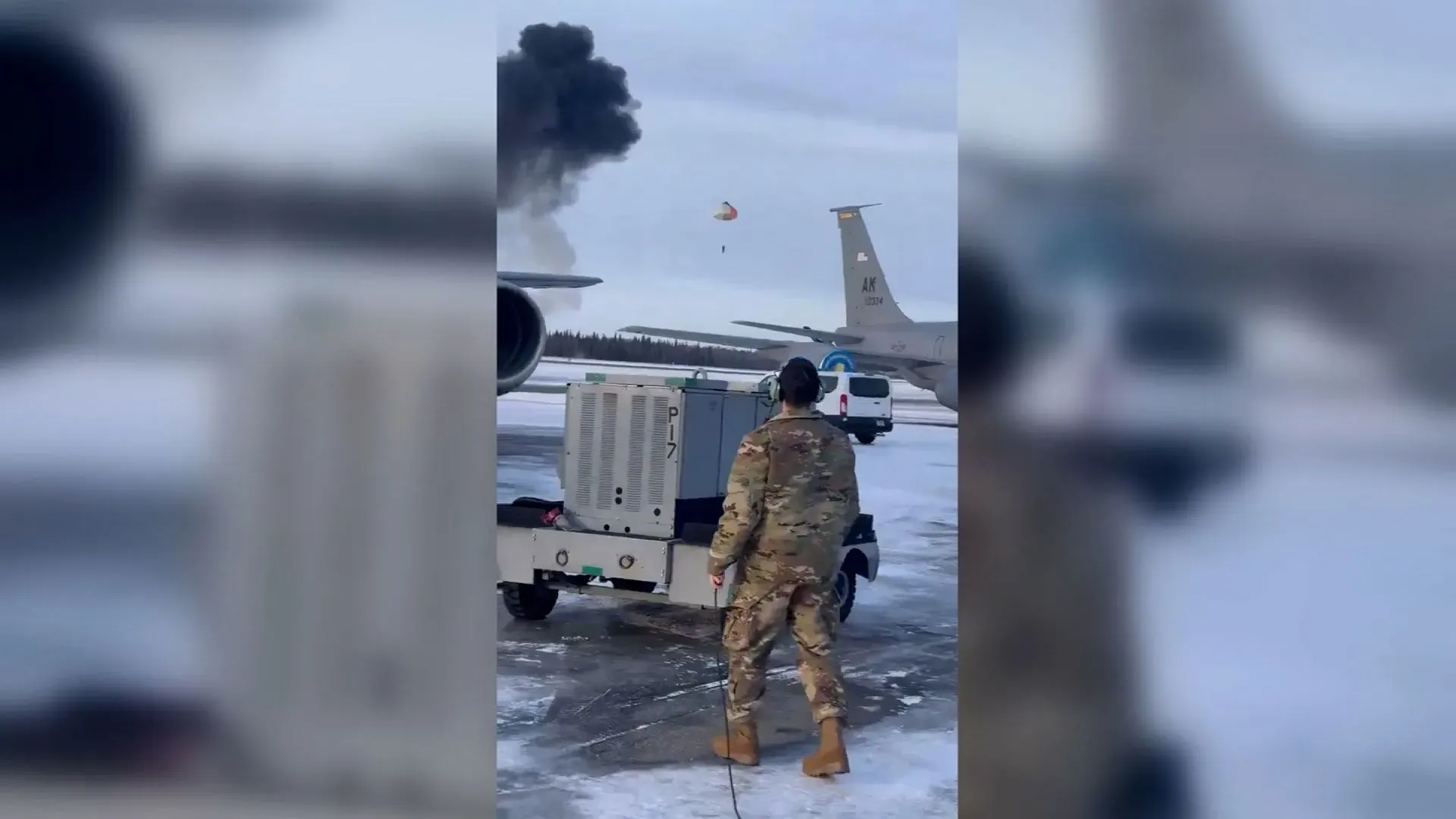 تصوير لحظة من حادث تحطم طائرة F-35 في قاعدة إيلسون الجوية بألاسكا، يظهر عموداً من الدخان ومظلة مفتوحة للطائر.