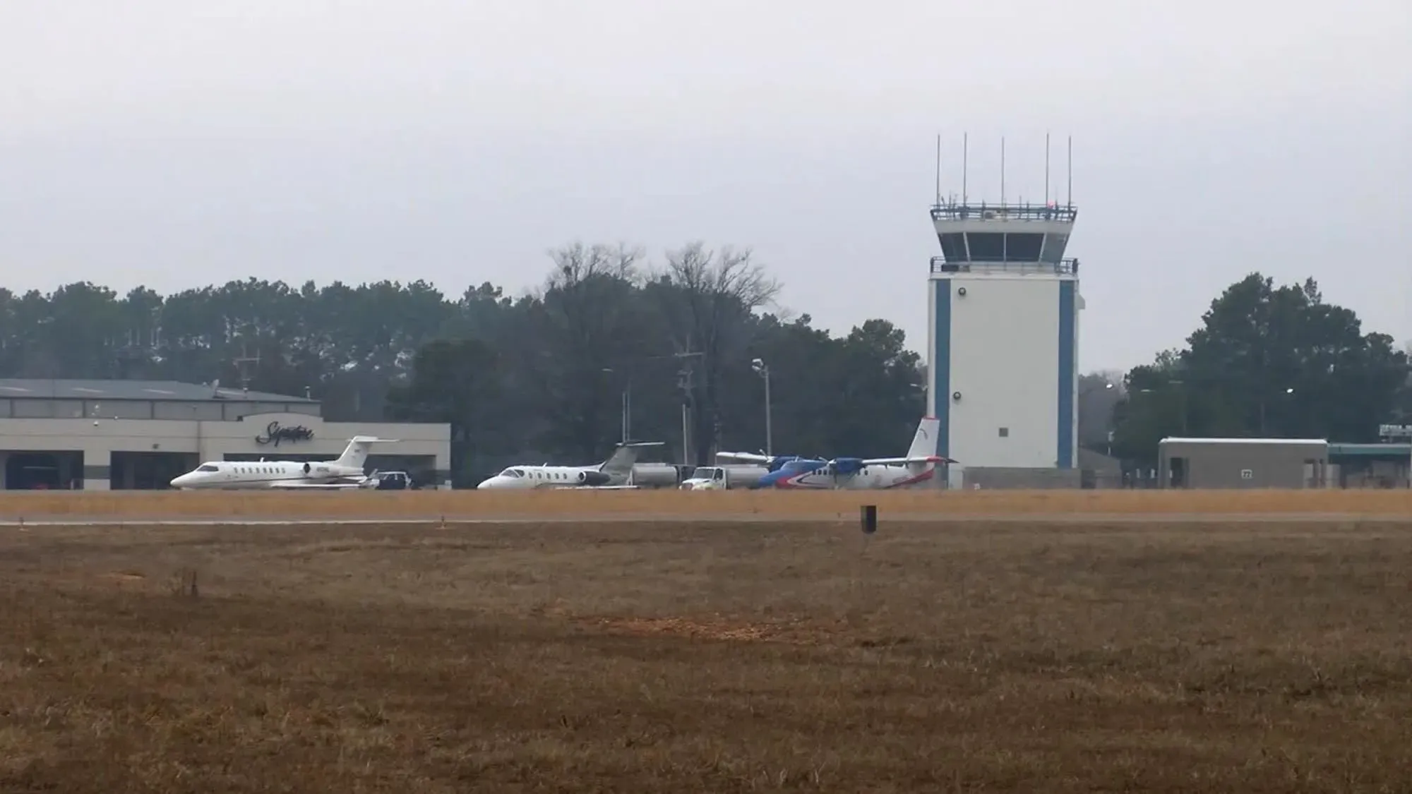 مطار تيكساركانا الإقليمي يظهر فيه طائرات على المدرج وبرج المراقبة، بعد حادثة تدخل طيار محلي لوقف مراهق مسلح.