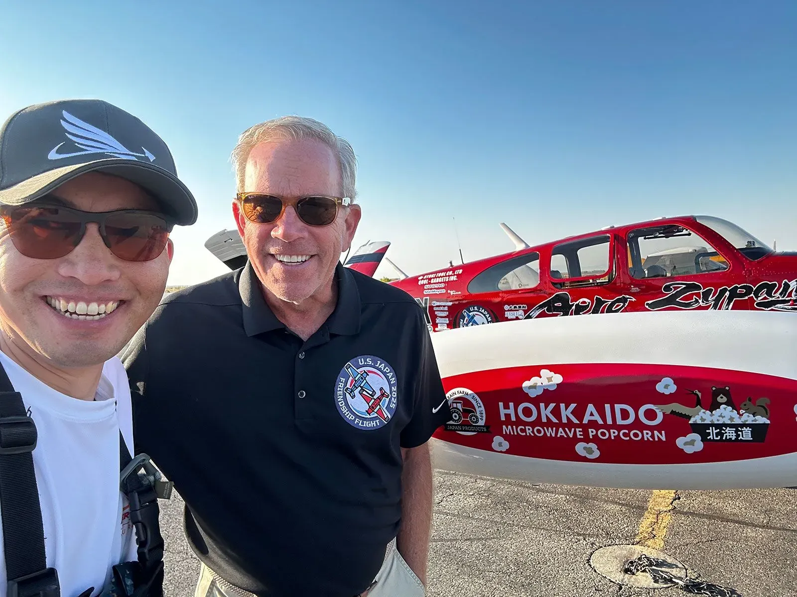 صورة لطيارين، شينجي مايدا وأدريان إيتشهورن، يبتسمان مع طائرتهما، رمز للصداقة بين اليابان والولايات المتحدة بعد الحرب العالمية الثانية.