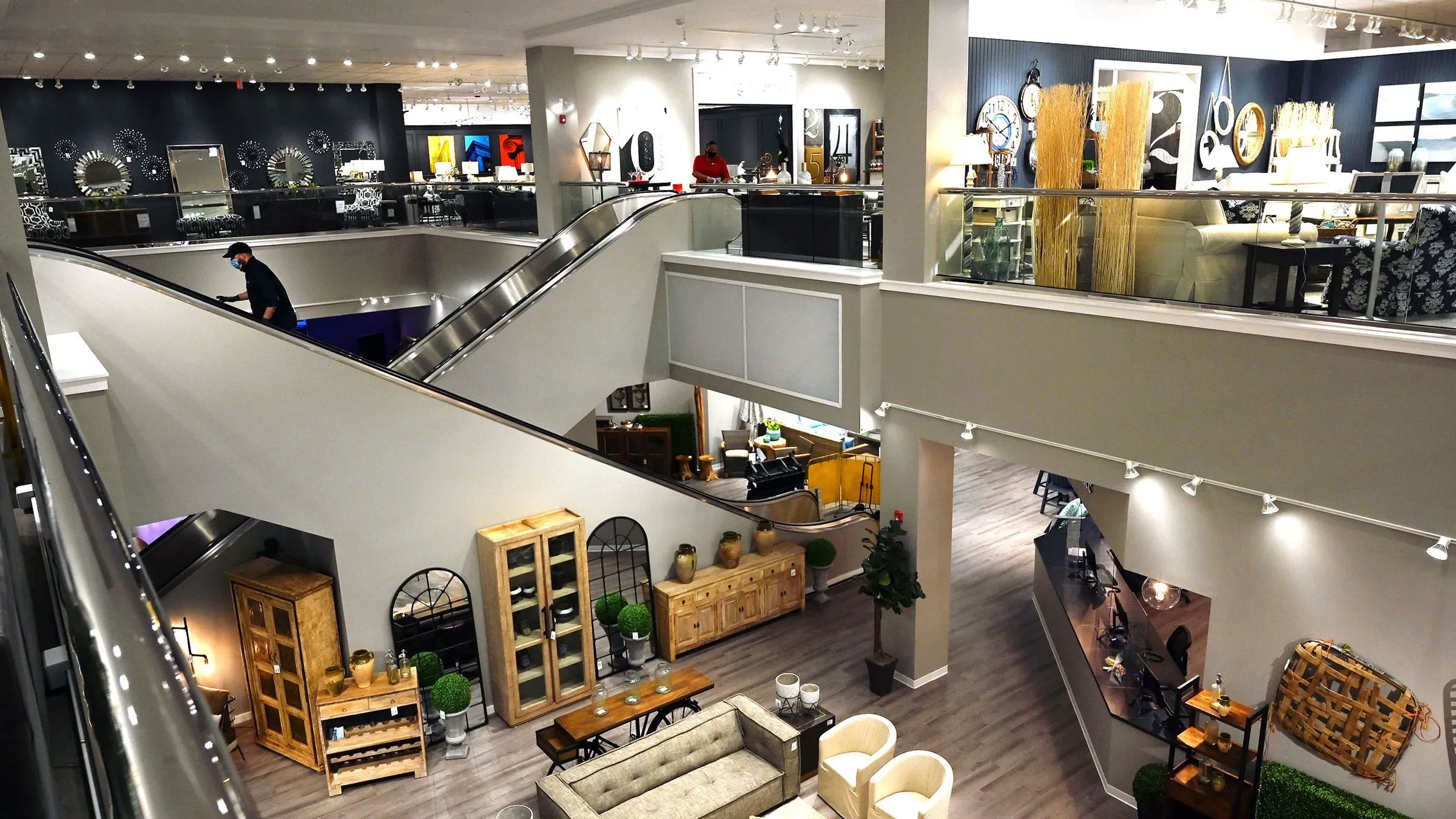 عرض داخلي لمتجر أثاث حديث، يظهر تفاصيل متنوعة من الأثاث والإضاءة، مع زبائن يتجولون في المعرض.