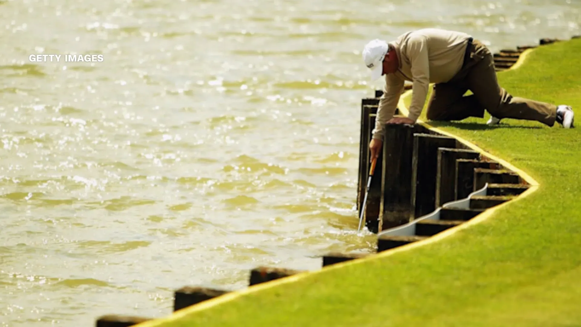 لاعب جولف يستخرج كرتة من المياه بجوار ملعب TPC Sawgrass، وسط أجواء عاصفة قبل الجولة النهائية من البطولة.